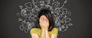 A woman with her head in her hands, her mind in chaos, having many thoughts at once